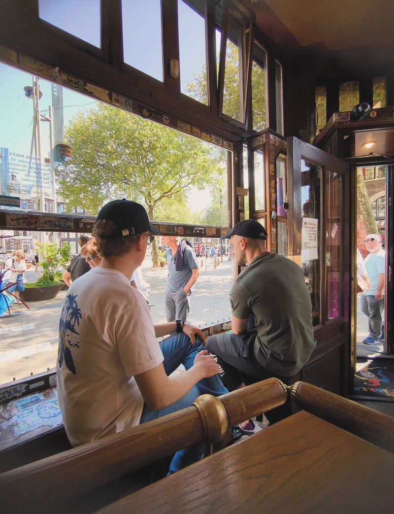 Bezoekers bij het open raam met uitzicht over de Nieuwmarkt